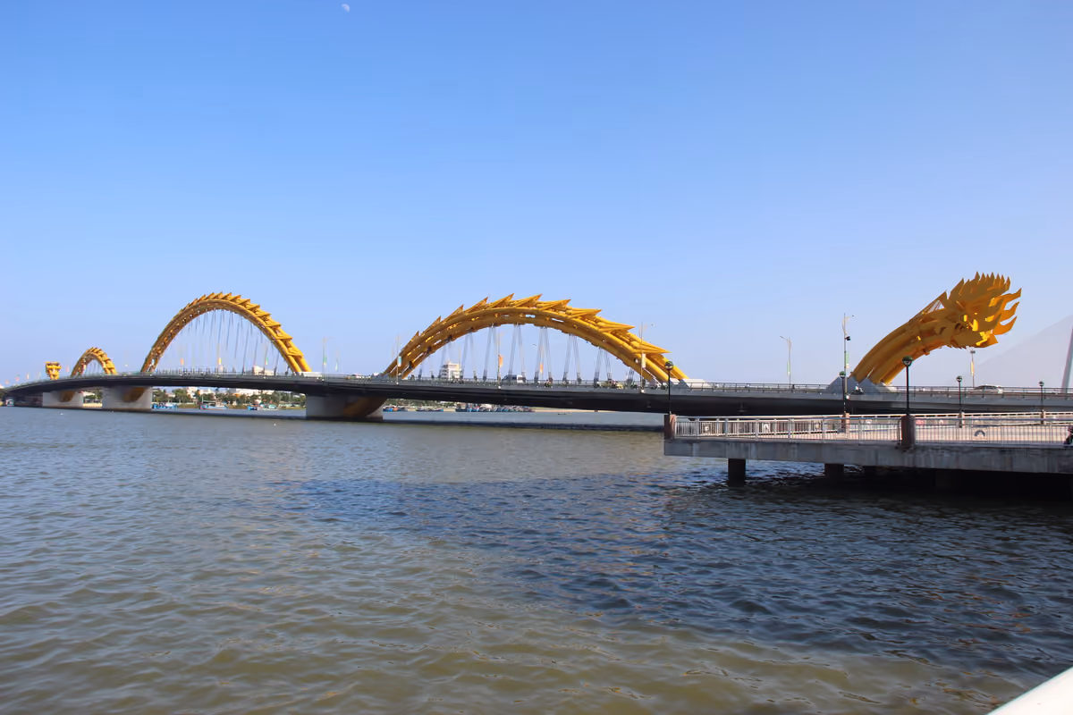 The Dragon Bridge, a long road bridge with yellow steel arches shaped like a dragon’s body, crossing the wide Han River under a clear blue sky
